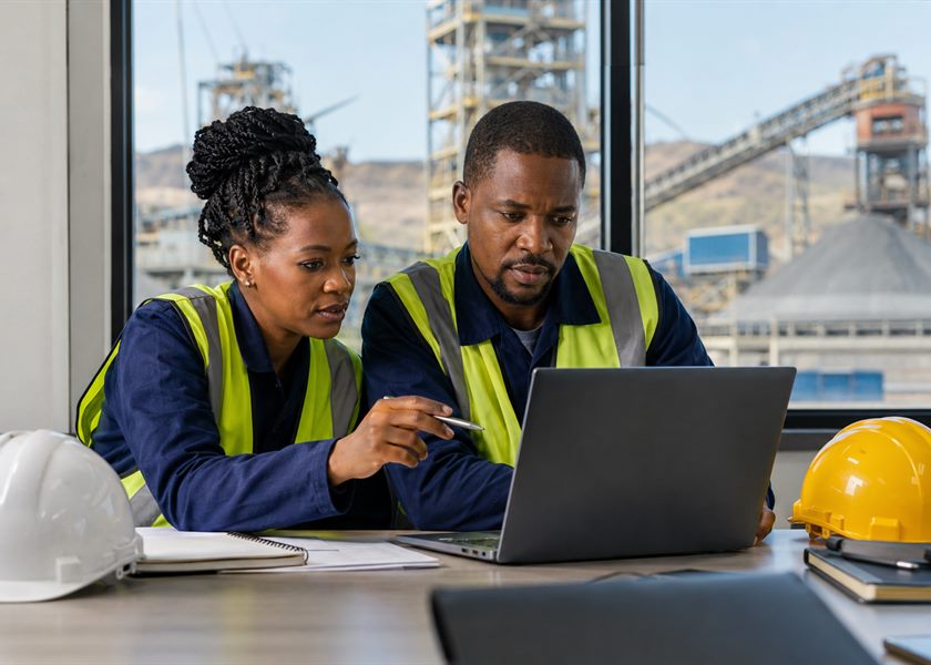 Two engineers reviewing operational data on a laptop in a site office